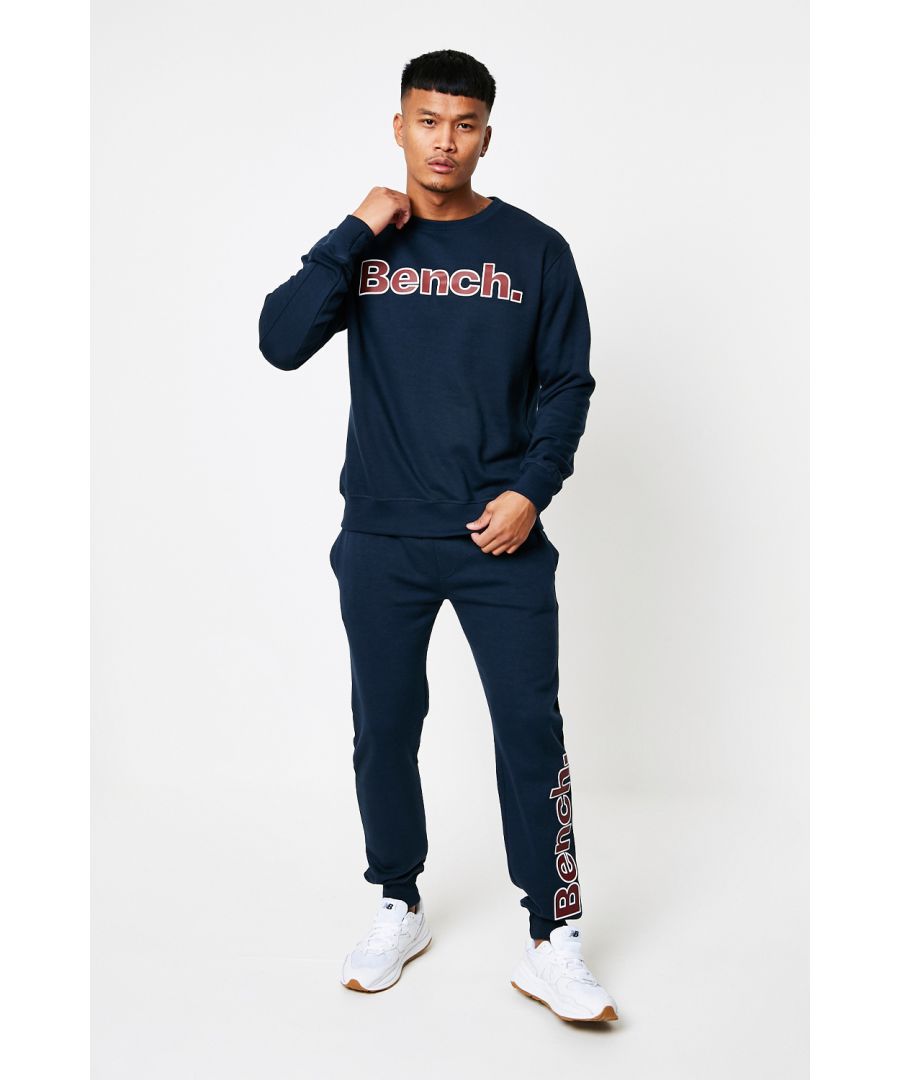 This ‘Benton’ tracksuit set from Bench is a ready-made outfit, the set includes a T-Shirt, a sweatshirt and a pair of joggers. All three items come in a matching colour and feature a printed Bench logo. The sweatshirt features ribbed cuffs and hem, a crew neck and a soft fleece lining. The joggers have a soft fleece lining, an elasticated draw cord waist, ribbed cuffs, two front pockets and one back pocket. This set is the ideal addition to your wardrobe, easy to wear and can be styled as a full tracksuit or as individual items.