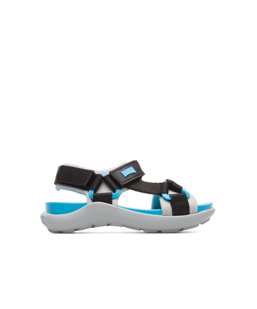 Kids’ multi-colored sandal with rubber outsole and Velcro straps. Black and blue details.\n\nDesigned for both land and water activities, Wous is made from protective leather and boasts a unique design for every summer endeavor.