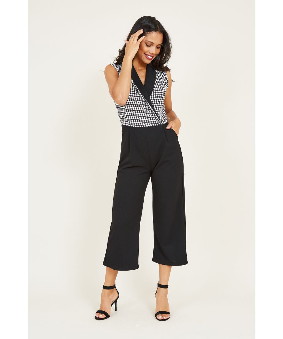 Smarten up your partywear with this stylish Mela Dogtooth Jumpsuit. Featuring a sleeveless wrap bodice decorated wtih a classic print, it's balanced by flared culotte trousers. Framed by a sleek collar, accessorize with heels or boots depending on the occasion.