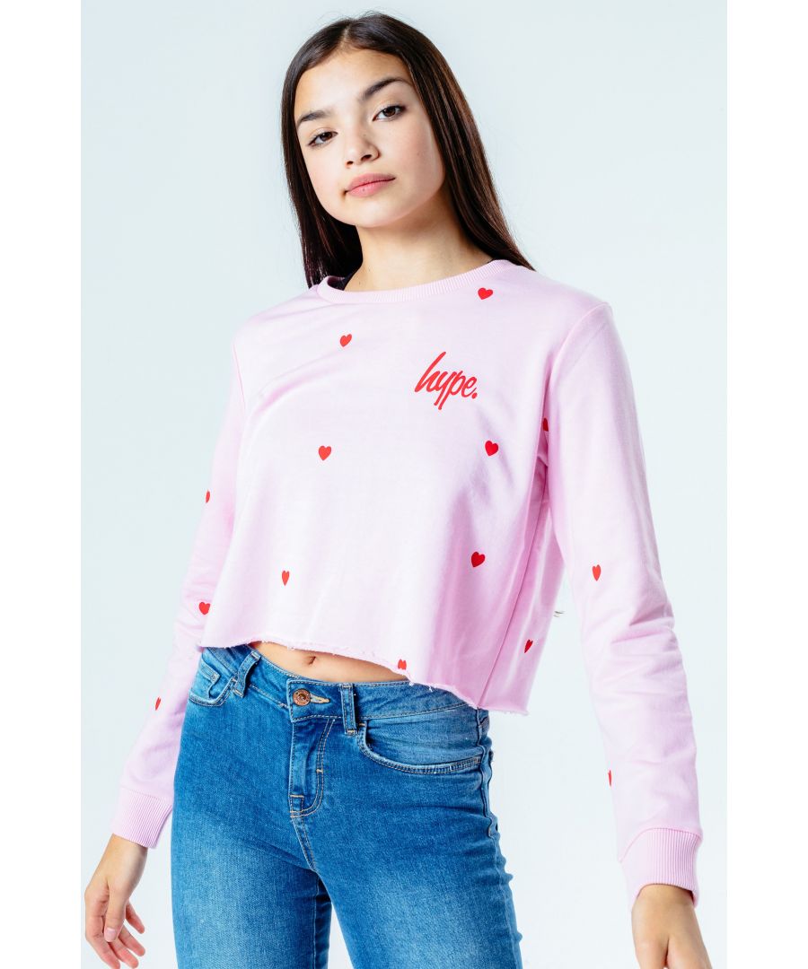 The cutest crop hoodie you'll need this season, and every season after that. The Hype. heart repeat girls cropped crewneck features our signature all-over heart print in a contrasting white. The fabric boasts a baby pink 80% cotton 20% polyester fabric base for the upmost comfort. With a crew neckline, long sleeves and fitted cuffs for a classic fit. Finished with the iconic mini Hype. script logo in a vibrant red. Wear with cycle shorts to stay on trend this season. Machine wash at 30 degrees.