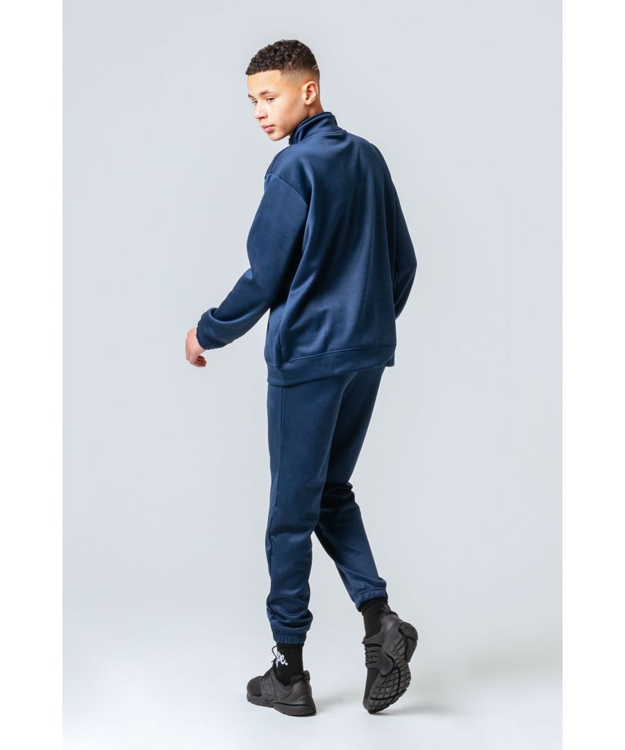 Level up your tracksuit collection with the HYPE. essential navy kids tracksuit. Designed in a scuba fabric, with a high-neck zip up jacket and our standard kids jogger shape. Wear with a plain tee underneath and box fresh kicks to complete your look.