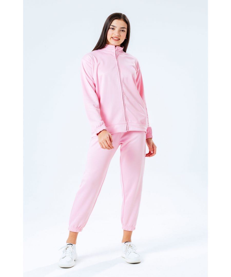 Level up your tracksuit collection with the HYPE. essential pink kids tracksuit. Designed in a scuba fabric, with a high-neck zip up jacket and our standard kids jogger shape. Wear with a plain tee underneath and box fresh kicks to complete your look.