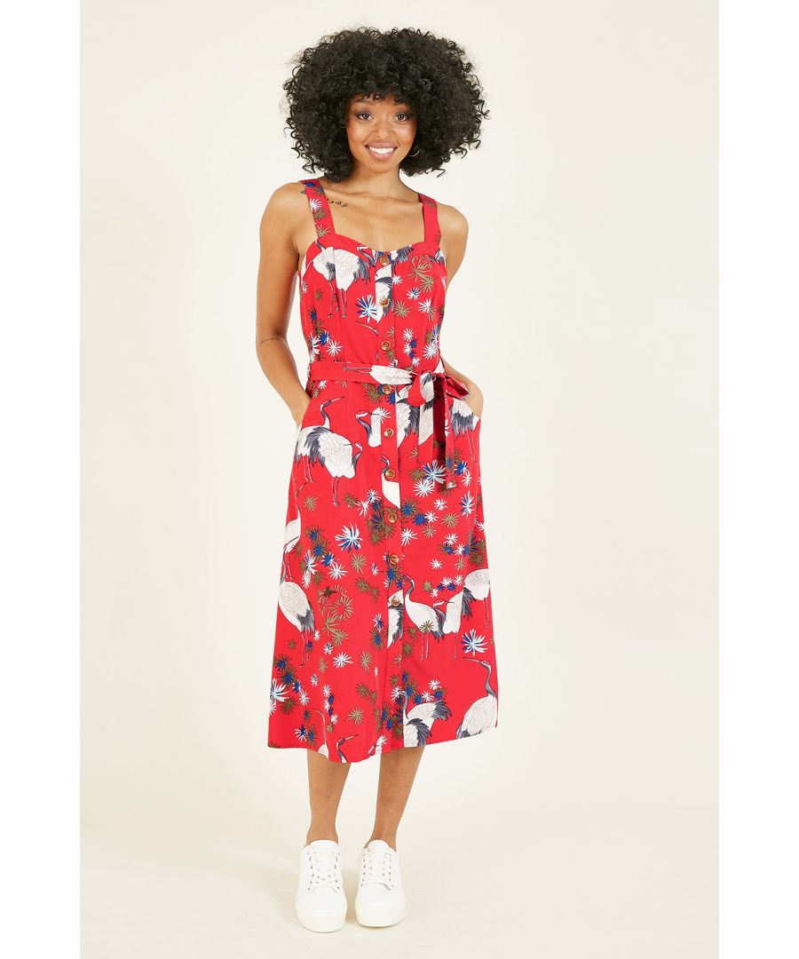 Deze zomer kun je niet heen om felle en gedurfde prints. Deze rode zonnejurk van Yumi met doorknoopsluiting en kraanvogelprint heeft ze allebei. Voorzien van een knoopsluiting, unieke all-over print en de nodige dikke knoopceintuur om je op de juiste plaatsen vorm te geven. Houd het casual met stevige sneakers of dress to impress met hoge hakken met bandjes en een bijpassende clutch.