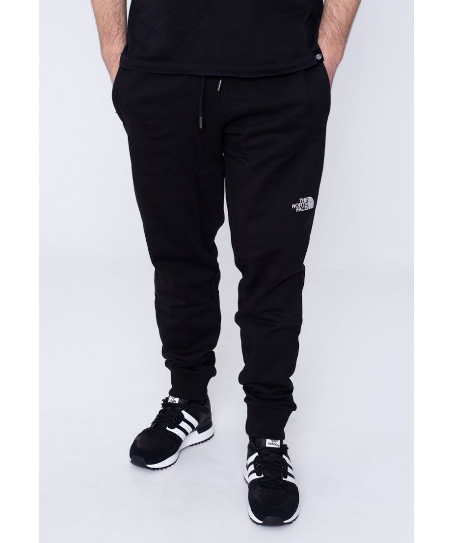 The North Face Mens NSE Pants Black.\nThe NSE Pants by The North Face Bolster Your Weekend Roster with Their Fuss-free Feel.\nSuper Soft Construction That Puts Comfort at The Forefront.\nZipped Pockets Hold Small Essentials.\nElasticated Waist with Drawcord Ties.\nCuffed Hem.\nEmbroidered Logos.