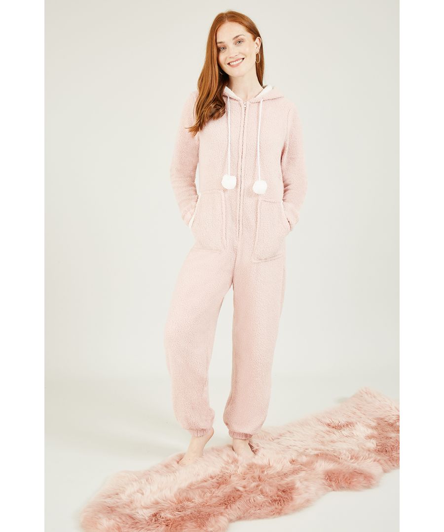 Snuggle up this season in this impossibly soft Yumi Blush Teddy Bear Onesie. This all-in-one features a zip up fastening, two large pockets, hanging pompoms and a cosy hood. Perfect for relaxing on chilly nights - an A/W season essential. Match with fluffy slippers for next level cosiness.