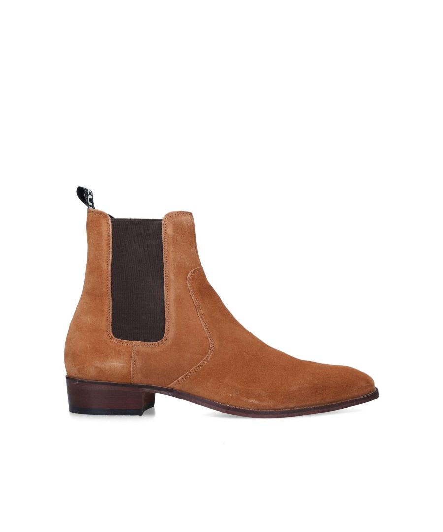 The Dylan ankle boot is crafted from a soft tan suede with dark brown elasticated panels at the ankle. The black and white branded pull tab sits at the back of the ankle.