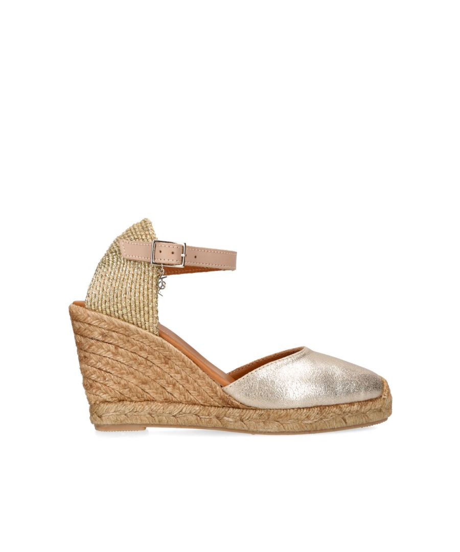 The KGL Monty espadrille heel arrives in a metallic gold leather with closed toe and rope effect heel. The tan ankle strap is fastened with gold buckle which features a small KGL charm. The heel height is 9cm.
