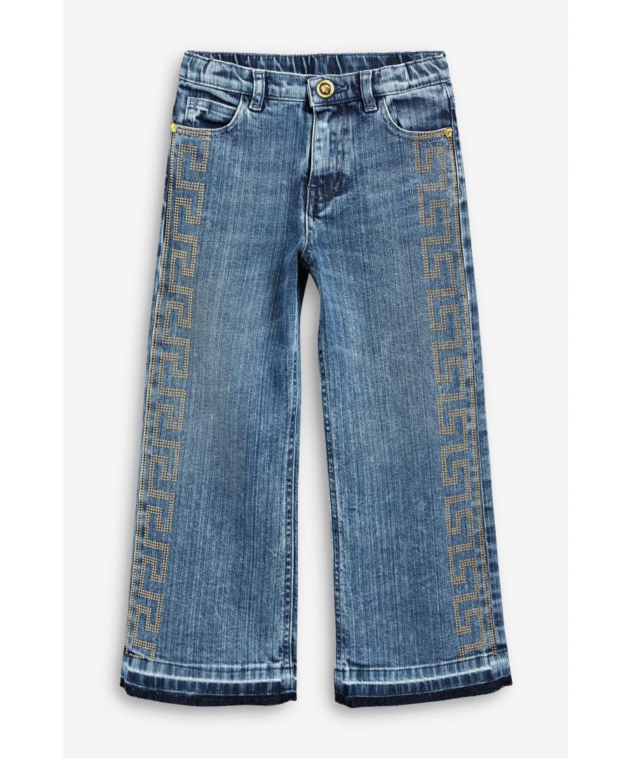 Girls blue jeans from Versace featuring the iconic Greek fret going down the legs in gold diamantes. The jeans have a gold Versace button fastening, front and back pockets with an straight leg design.