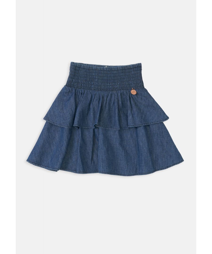 Ooh such a goodie! Our dark chambray rara skirt with shirred waistband is super comfy in super soft cotton denim with tiered skirt  it’s a summer wardrobe essential! Wear with matching shirred denim top for the perfect co-ord.  Model wears 10y  she is 10 years old and 143cm tall.  Angel & Rocket cares - made with Fairtrade cotton  Colour: Dark Blue  About me: 100% Cotton  Look after me – Think planet  wash at 30c