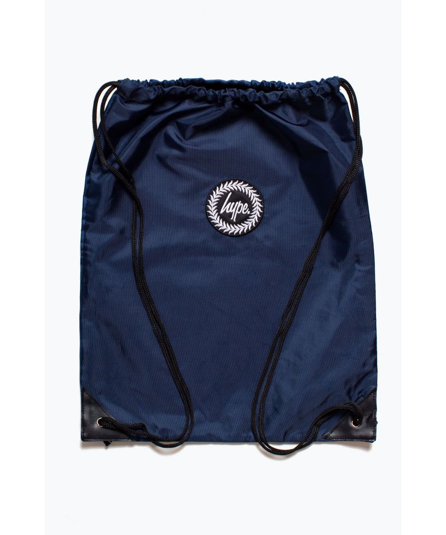 The HYPE. Navy Crest Drawstring Bag, the classic you can't live without. Designed in our standard unisex drawstring bag shape and style, perfect for girls, boys and gender-neutral. The perfect lightweight bag for those days when you only need to carry essential goods aka all the snacks. This drawstring bag doubles up as the ultimate P.E bag or gym bag. Measuring at 52.5cms x 42cms, this will fit your water bottle and sports kit perfectly. Wipe clean only.