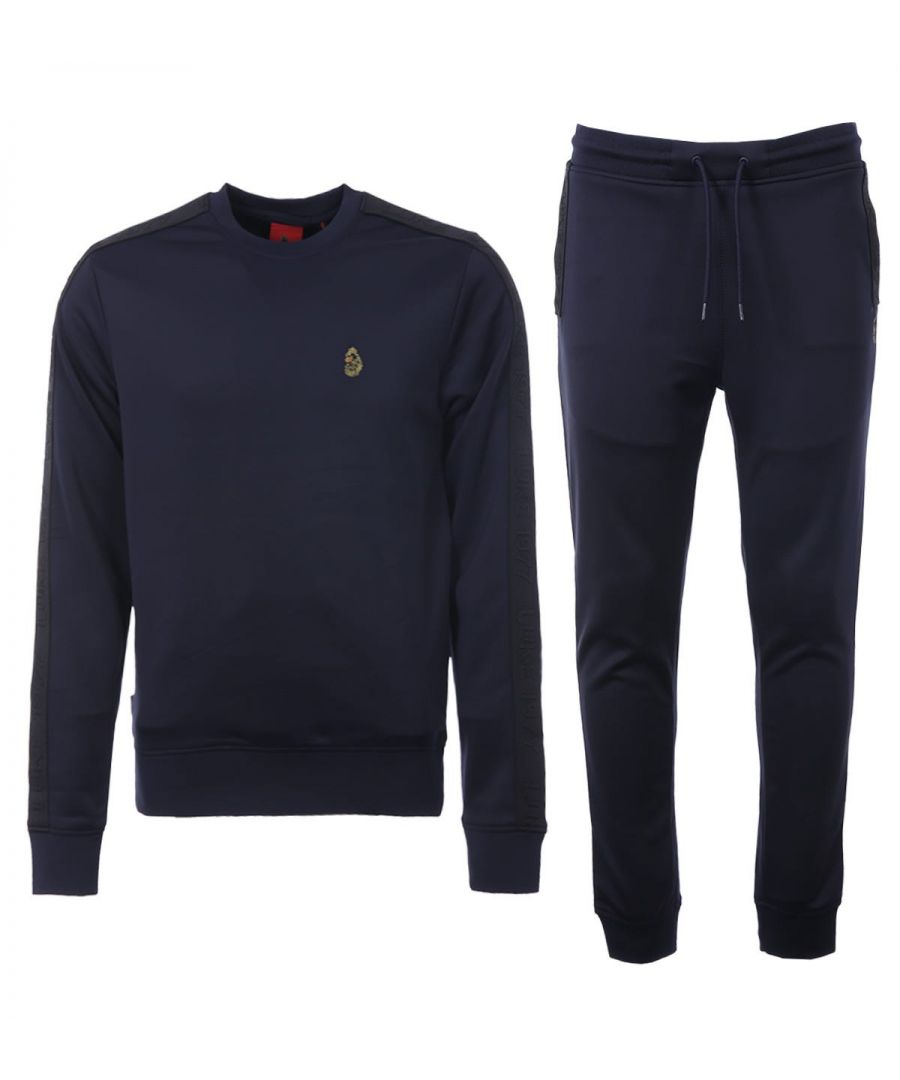 Luke 1977 is, without a doubt, the go-to brand if you're after well-crafted, witty and masculine products. Finished with the signature Luke Lion logo, you're looking at one of the UK\'s top contemporary menswear brands.This Tracksuit set includes the Tape logo Joggers and Tape Logo Crew Neck Sweatshirt. Both are crafted from a stretch poly smooth fabric, featuring Luke 1977 raised text tape detailing at the seams. The joggers are fitted with a drawstring waist and ribbed cuffs, whilst the sweatshirt is fitted with a classic crew neck design with ribbed trims. Regular Fit, Stretch Polyester, Tracksuit Set, Tape Logo Joggers, Tape Logo Crew Neck Sweatshirt, Luke 1977 Branding. Style & Fit:Regular Fit, Fits True to Size. Composition & Care:94% Polyester, 6% Elastane, Machine Wash.