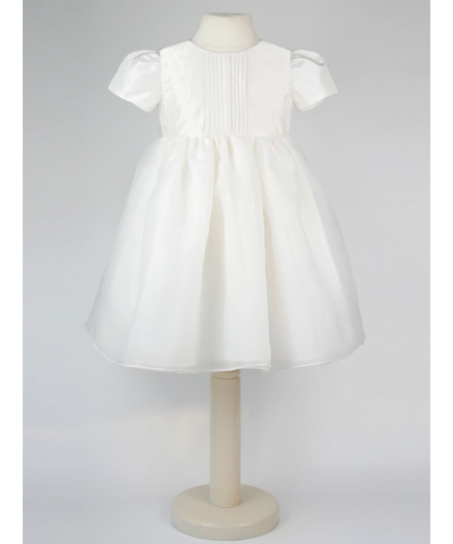 Perfect for Flower Girls, Bridesmaids or Special occasion!\n'Dolly' evolved from one of our most popular dresses.\n\nIt has been beautifully re-designed to include our pin tuck detailed front, button back and gorgeous puffed sleeves to create the prettiest of dresses that is as comfortable as it is fun. Team it with a sash, ribbon or flower in any colour to match your colour scheme.\n\nYou'll find all our dresses are lined in cotton lawn for extra softness and perfect for sensitive skin.\n\nThe dress will arrive with you on a Satin padded hanger and covered in one of our Heritage garment protector bags for safe keeping.\n\nOuter - 100% Mock Silk polyester fabric and trims\n\nLining - 100% cotton\n\nDry Clean or Hand Wash