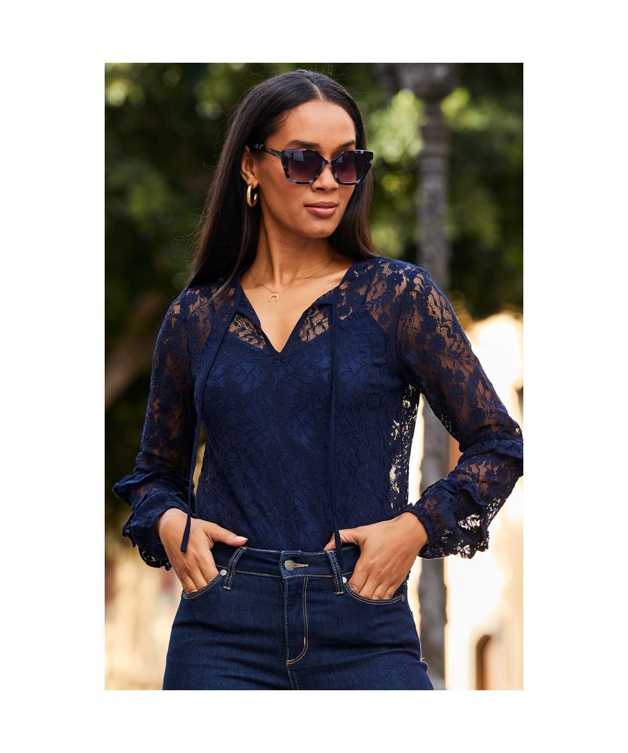 REASONS TO BUY:\n\nLuxe up your look\nCrafted from stunning navy blue lace\nSexy sheer sleeves and neck\nGorgeous ruffle trim detail\nComes with a cami\nAdd your favourite skinnies or black wide-leg trousers