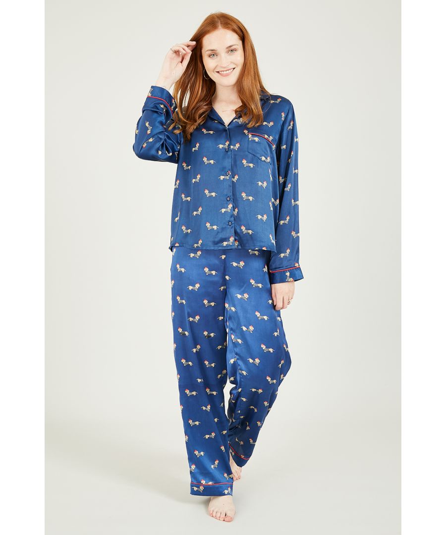 Nachtkleding, maar dan luxe. Deze marineblauwe satijnen pyjama met teckelprint heeft een volledige knoopsluiting, een kraag, lange mouwen en één zak. Een loose-fit broek en een satijnen pyjamatas maken de 3-delige set compleet. Maatwijzer: S = 8-10 M = 10-12 L = 12-14