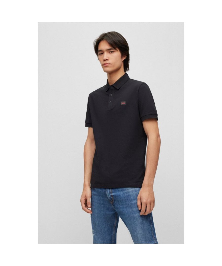 A slim-fit polo shirt in breathable piqué with a logo patch in signature red by HUGO Menswear.\nSlim fitFlat-knit collarNumber of buttons: 3Short sleevesFlat-knit cuffsSide slitStandard length\n100% Cotton\n50490770