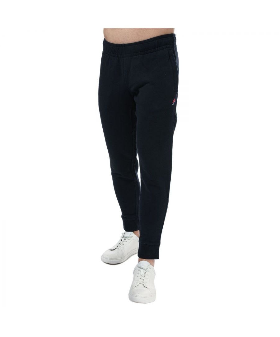 Mens Superdry Code Essential Jog Pants in navy.- Drawstring elasticated waistband   hidden on the inside.- Three pocket design.- Ribbed cuffs.- Embroidered logo.- Signature logo patch.- Tapered fit.- Main material: 100% Cotton. Machine washable. - Ref: M7010667AJKE
