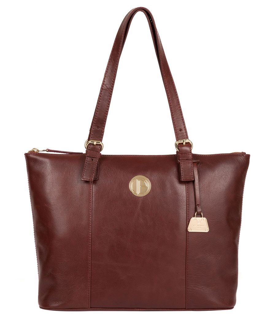 The 'Aster' tote bag from Pure Luxuries London's Bloomsbury Collection is crafted from natural leather with a soft touch. Spacious and stylish, the central compartment is lined with a natural 100% cotton lining which is complemented by two slip pockets and a slip pocket on the rear of the bag, providing on-the-go storage for all your essentials. Gold-coloured fittings adorn the bag and the adjustable leather handles to match the bag and the wearer perfectly. Finished with the Pure Luxuries London logo and charm.