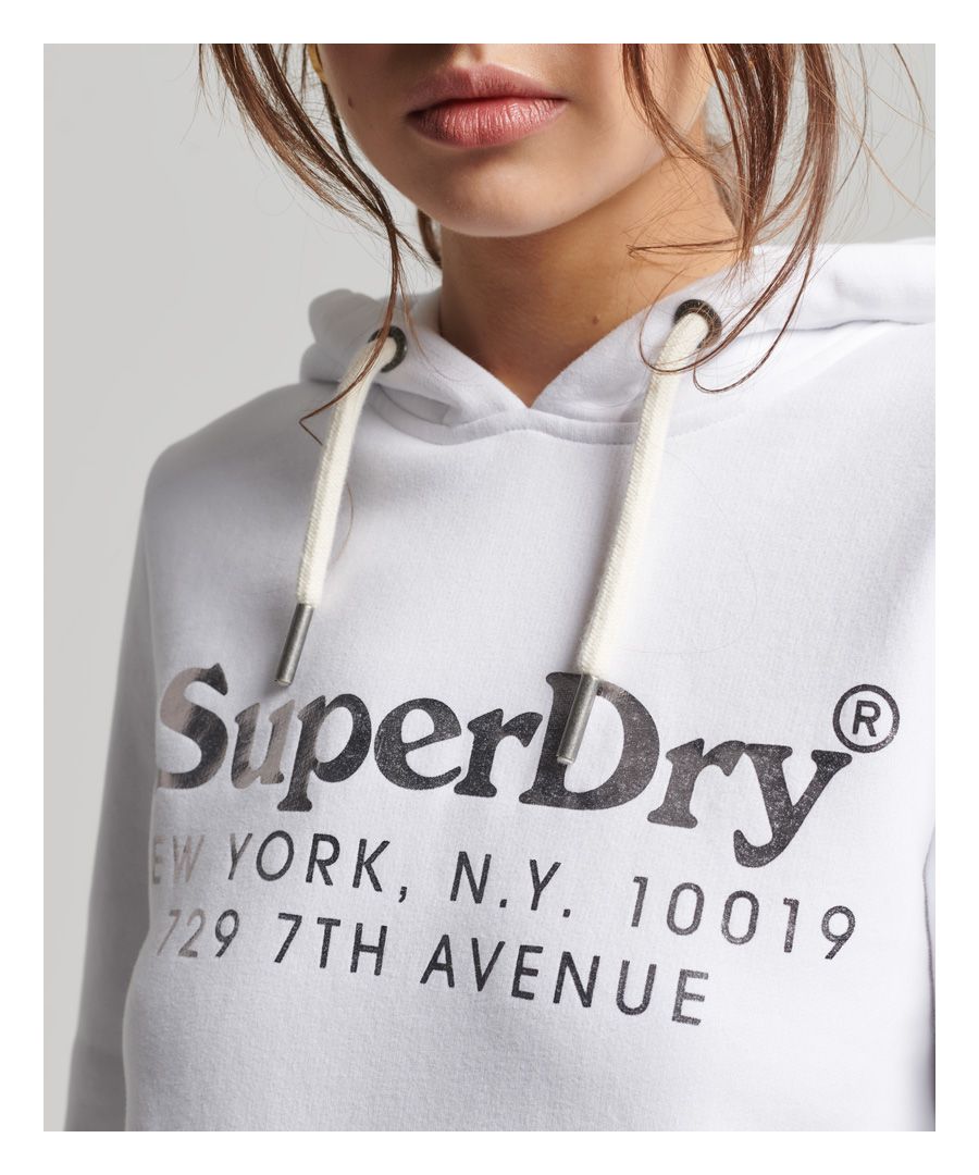 We love to tap into those old-school vibes when it comes to our vintage range, utilising names and locations that evoke nostalgia for the past. In particular, New York City inspires us through the stories of its workmen and rich, unique culture. When you rock this classic hoodie with its signature softness, you'll also be representing our Superdry family in a retro style.Relaxed fit – the classic Superdry fit. Not too slim, not too loose, just right. Go for your normal sizeDrawcord hoodLong sleevesPrinted graphic and logoRibbed cuffs and hemFront pouch pocketSignature Superdry tab