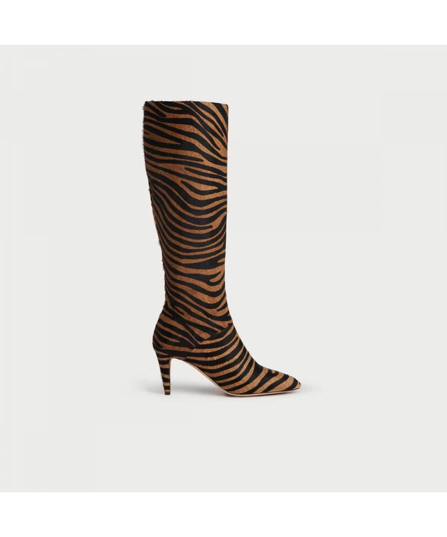 Statement boots don't come wilder than Gini. A real stand-out style and incredibly luxurious, they are crafted from tactile calf hair emblazoned with a zebra print in natural tones. Zipping up to the knee, they have a pointed toe and a slender heel. Designed for playfulness, wear them with tonal colours or mix and match with autumnal prints.