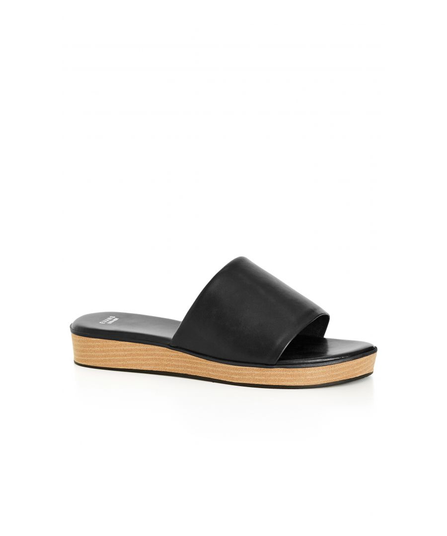 Amplify your look with the serious glamour of the black Band Slide Wedge. In a soft faux leather, these slip-on shoes keep you comfortable with their wide fit and low platform heel for all-day ease. Key Features Include: - Round open toe - Single thick band - Faux leather fabrication - Slip on style - Chunky wood-stacked platform sole - Low wedge heel