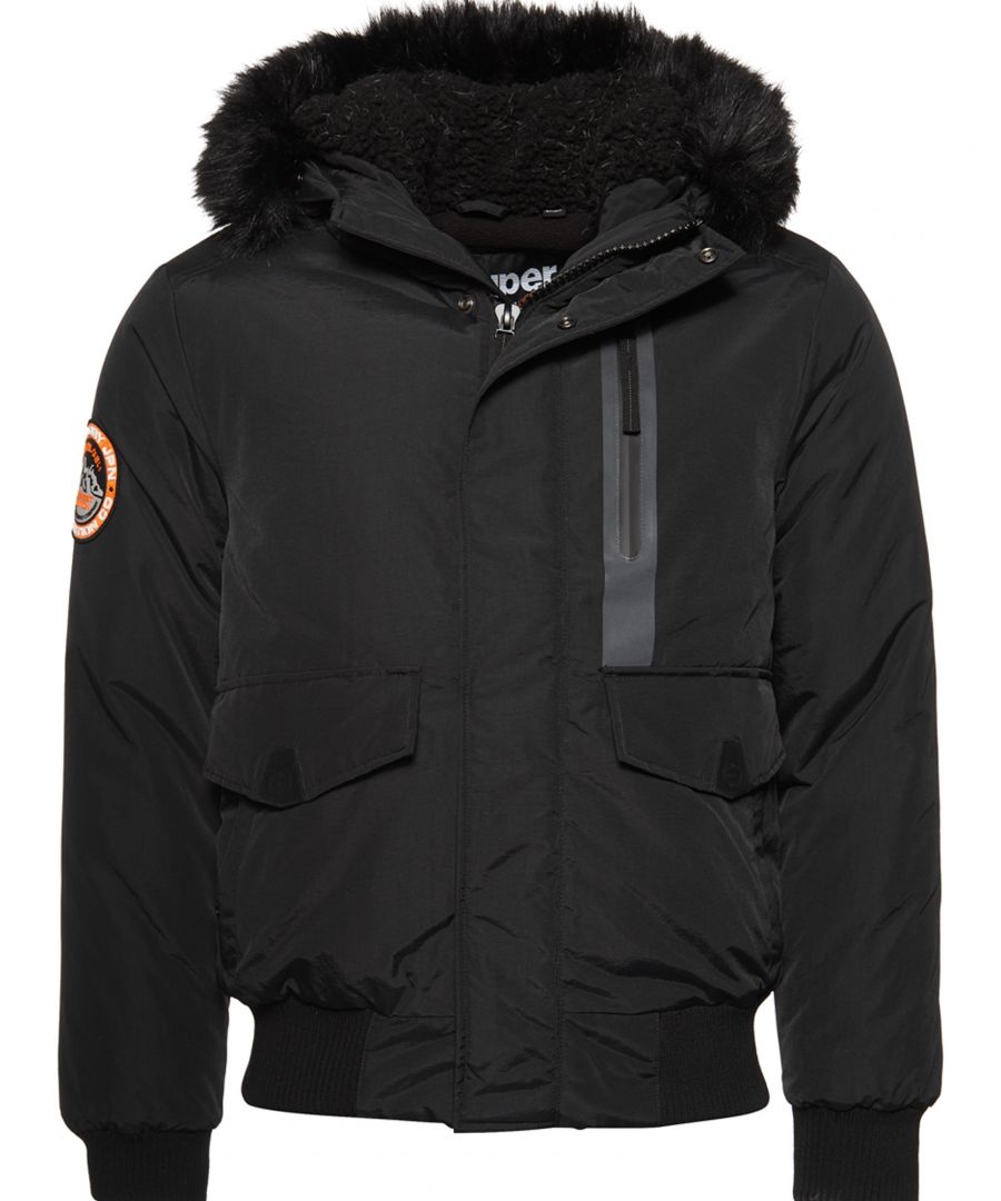 Superdry men’s Everest bomber jacket. Stay warm this season in this Everest bomber-style hooded jacket, featuring a faux fur detachable trim, bungee cord adjustable hood and a popper and single zip fastening to keep the wind out. The Everest bomber has five external pockets and one internal pocket to keep your belongings safe. For the finishing touches, the Everest bomber has been designed with ribbed cuffs and hem as well as a Superdry badge on the sleeve to incorporate both comfort and style.