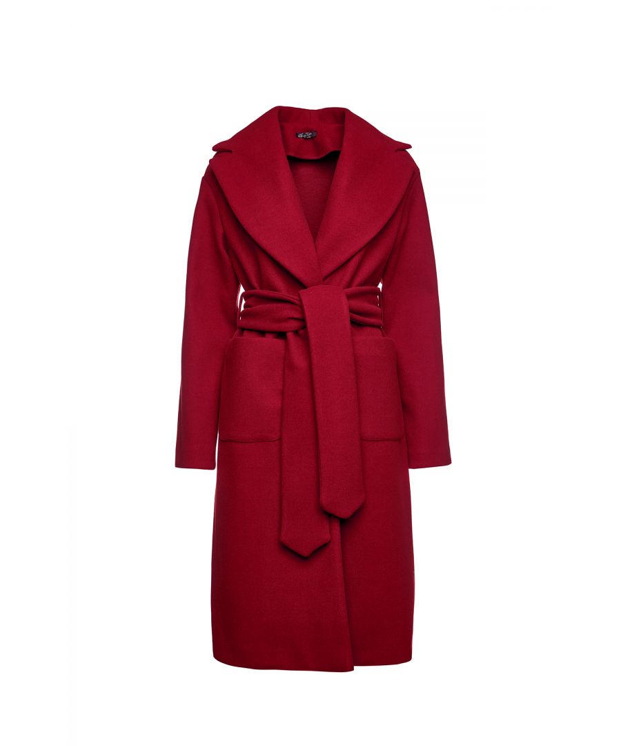 This long dark red coat is crafted in faux mouflon style fabric. There are large square patch pockets on either side. It has a large lapel and drop shoulders. The coat fastens in the front with 2 large black plastic buttons. At the waist it has belt loops on the left and right so that it can be worn with the 9cm wide belt which is in the same fabric. The coat has big slits on either side. It is styled in a straight silhouette. This piece is ideal for wear in the day or for an evening out.