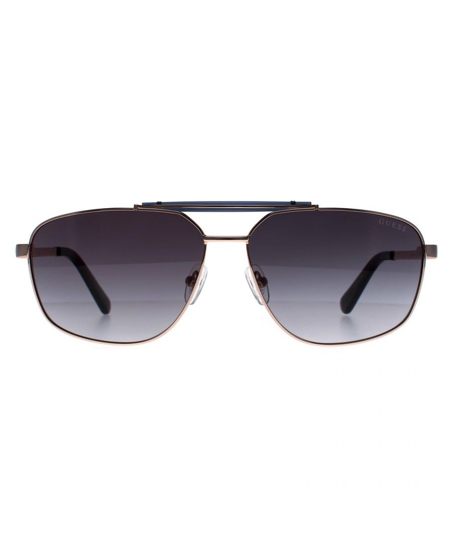 Guess Aviator Mens Gold Smoke Gradient GU00054  Sunglasses is crafted from high-quality metal, which is both lightweight and durable. The frame features a aviator shape with a double bridge, giving it a unique and fashionable look. The temples are adorned with the Guess logo, adding an extra touch of elegance to the design.