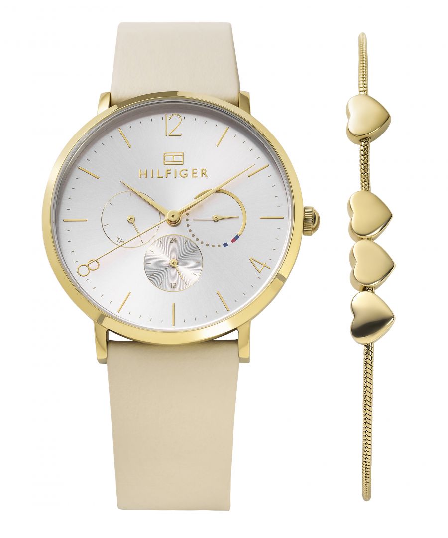 This Tommy Hilfiger Jenna Multi Dial Watch for Women is the perfect timepiece to wear or to gift. It's Gold 39 mm Round case combined with the comfortable Beige Leather watch band will ensure you enjoy this stunning timepiece without any compromise. Operated by a high quality Quartz movement and water resistant to 3 bars, your watch will keep ticking. This elegant watch includes a Gold stainless steel heart bracelet -The watch has a Calendar function: Day-Date High quality 19 cm length and 16 mm width Beige Leather strap with a Buckle Case diameter: 39 mm,case thickness: 8 mm, case colour: Gold and dial colour: Silver
