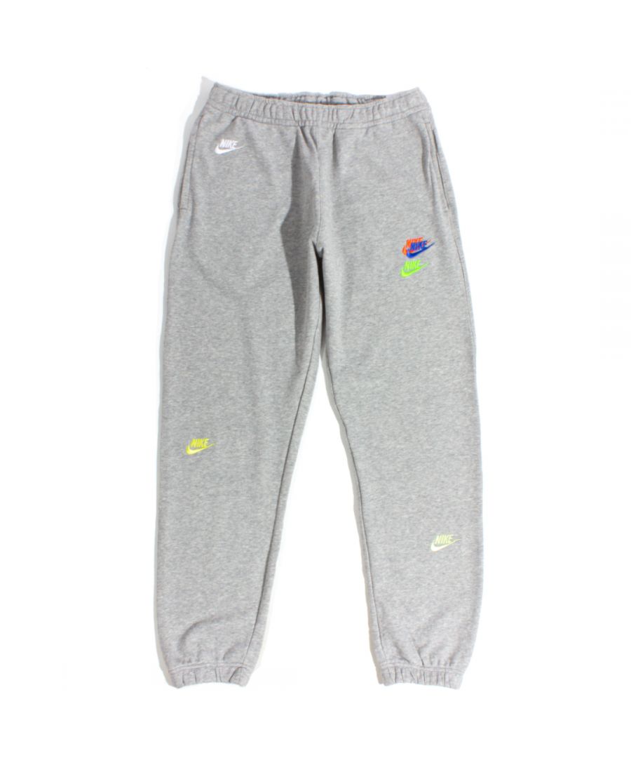 Nike Multi Futura Fleece Joggers in Grey. Built with an iconic fleece inner with an athletics-inspired design for a comfortable, casual feel ready for cooler weather. A lounge-friendly style features a slight taper for the perfect fit, featuring an elasticated waistline, cuffed ankles and a multi embroidered futura swoosh design.