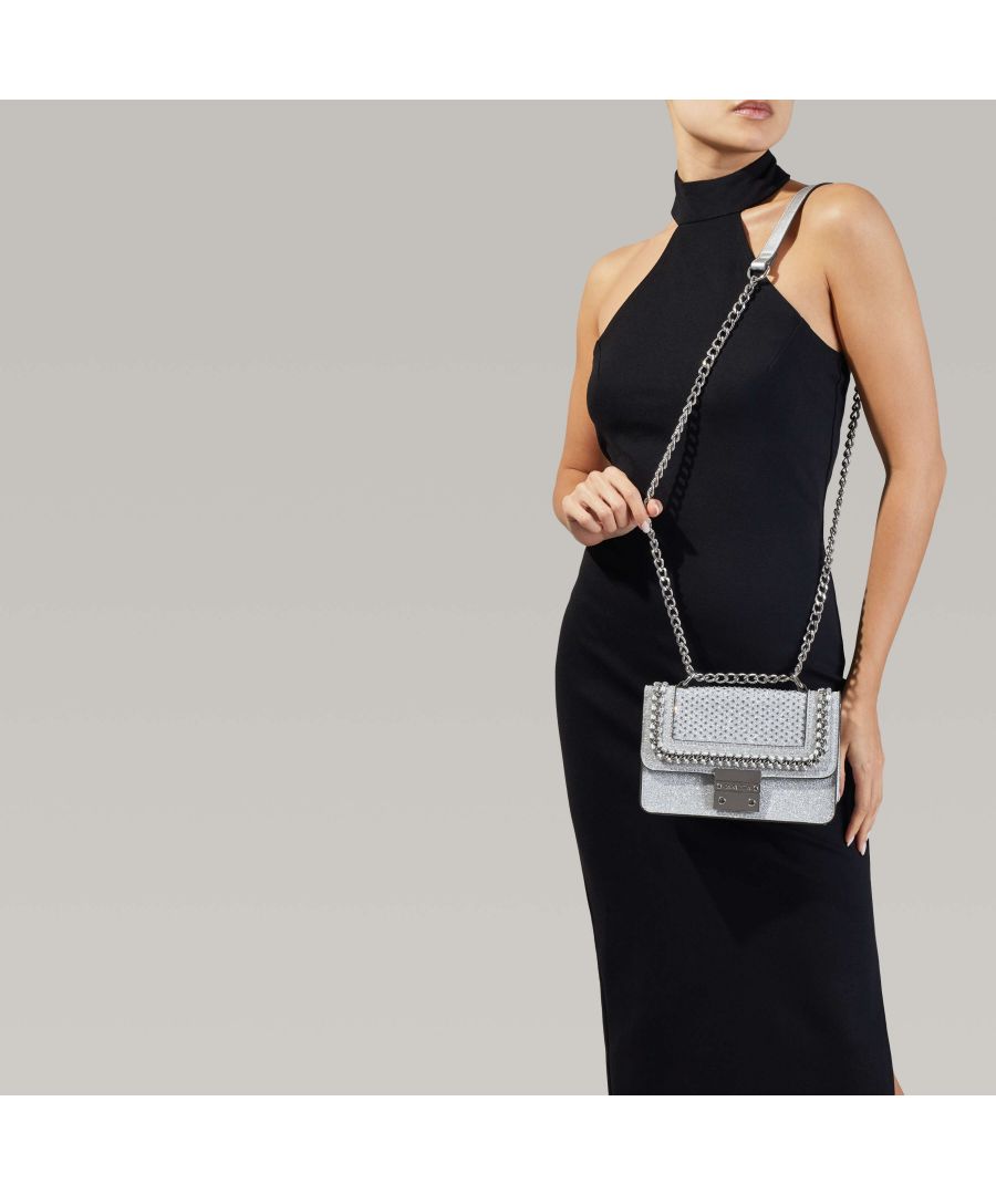 Lift every outfit out of the ordinary with Carvela's Mini Bailey Cross Body Bag. Swinging from a long silver-tone chain for cross-body versatility, this handbag is designed in a sparkling silver heat-seal fabric with chain and stud detail to the fold over flap, trimmed with a signature branded lock at the front flap.