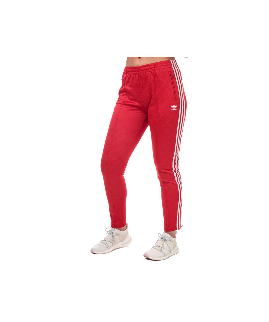 Womens adidas Originals SST Tracksuit Bottoms in scarlet.<BR><BR>- Elasticated waistband with inner drawcord.<BR>- Zipped front pockets.<BR>- Embroidered Trefoil and adidas wordmark at left thigh.<BR>- Allover jacquard logo inspired by a retro adidas sockliner design.<BR>- Applied 3-Stripes to sides.<BR>- Pintuck seams at front legs.<BR>- Ankle zips for easy on - off.<BR>- Mid rise.<BR>- Slim fit.<BR>- Inside leg length measures 28.5“ approximately.  <BR>- Main material: 83% Polyester  14% Recycled polyester  3% Elastane.  Pockets: 100% Recycled polyester.  Machine washable.<BR>- Ref: ED7462<BR><BR>Measurements are intended for guidance only.
