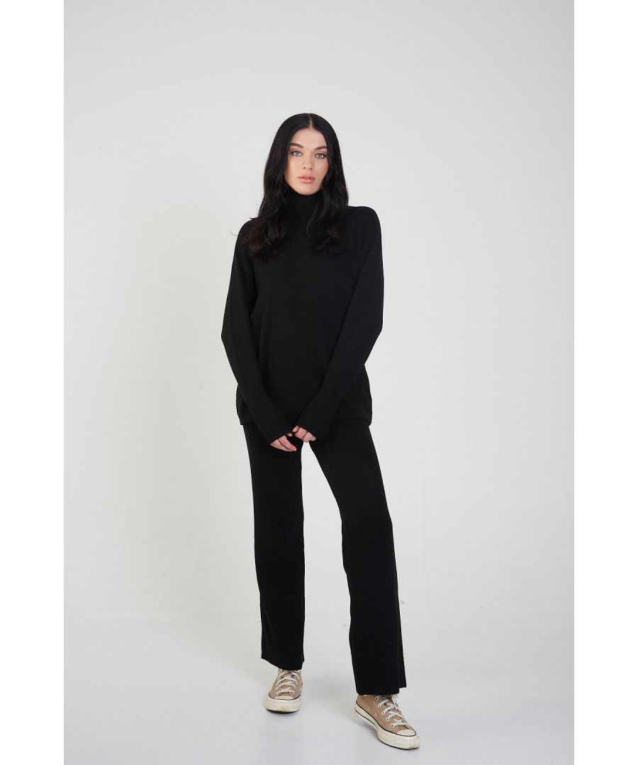 With our Roll Neck Knit Jumper and Trousers Set, you can relax in style. Featuring an oversized knitted top with a rolled high neck, dropped shoulders, and long ribbed cuff sleeves, make a statement with the matching trousers and a new pair of white sneakers. This matchy-matchy trend is always on, as co-ord sets simplify style for an off-duty look.