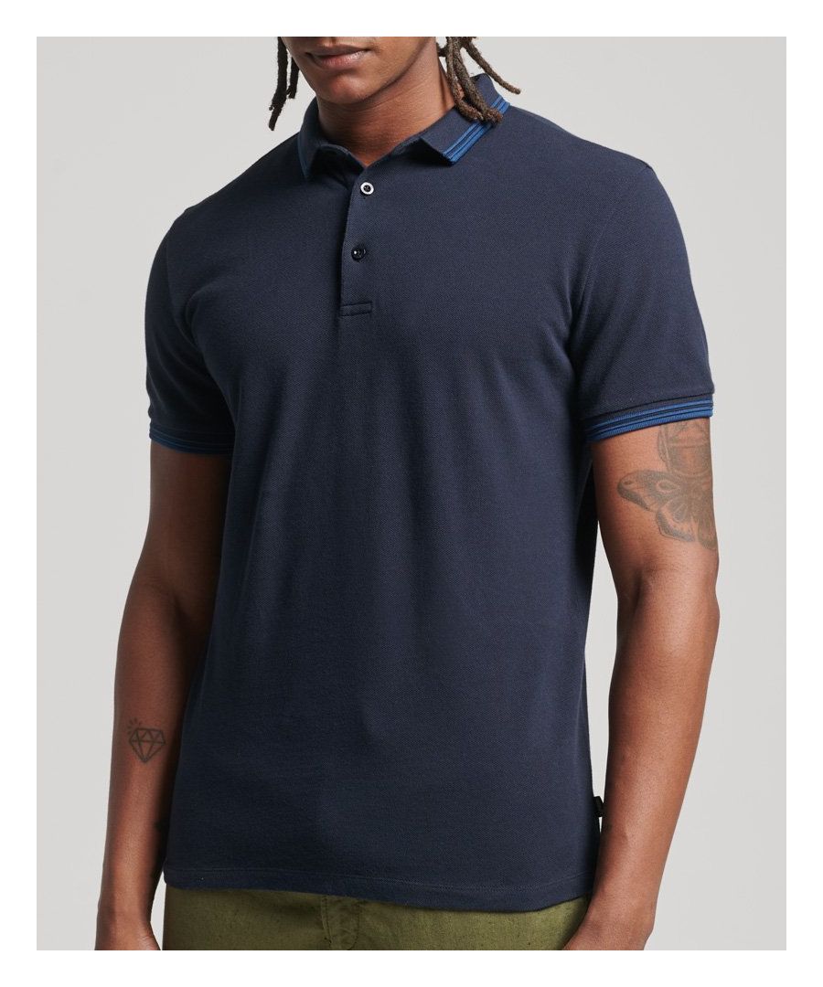 Ben je op zoek naar een elegante manier om je pologame naar een hoger niveau te tillen? Onze polo van biologisch piquékatoen met gestreepte kraag is je beste optie. Het fijne kleurdetail geeft je sobere look precies de ontbrekende stijltouch.Losse pasvorm – de klassieke Superdry-pasvorm. Niet te nauwsluitend, niet te ruim, precies goed. Kies je gebruikelijke maatKorte mouwenStrepen op de kraag en manchettenEnkele kraagKnoopsluitingSplitten in de zijnadenKlassiek Superdry-labelGemaakt van biologisch katoen dat wordt geteeld met natuurlijke in plaats van chemische pesticiden en meststoffen. De gezondere bodem die hierdoor ontstaat verbruikt tot 80% minder water, wat beter is voor onze planeet en voor de boeren die de grond verbouwen.