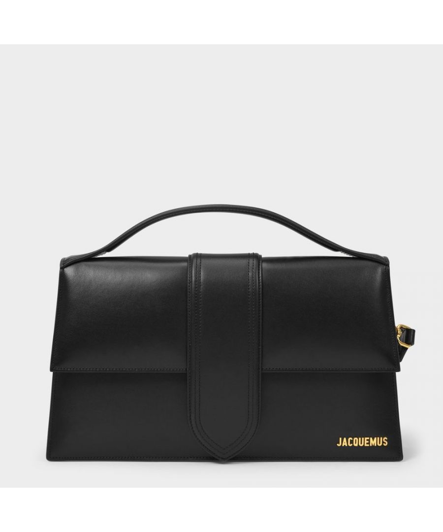 Inspired by the cult bag Le Bambino, the absolute must-have from Jacquemus, the Bambinou emulates the Bambino's sharp design and graphic lines. It features a long handle that means you can wear it elegantly on your shoulder, it comes in a timeless shade of black, that will add a touch of elegance to your most sophisticated outfits. Worn two ways - Detachable shoulder strap. Material : 100% Calfskin. Lining : Cotton. Colour : Noir - Black. Closure : Magnetic Flap Clasp. Interior : Patch pocket.
