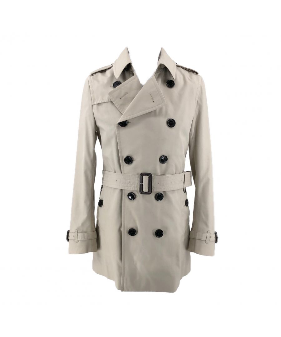 VINTAGE. RRP AS NEW. The classic Burberry trench coat completes every stylish wardrobe.This elegant piece is a double breasted with black buttons and a waist belt with buckle. The buttons and belt on the collar allow the coat to also be worn with a high neck.The neck has a hook and eye closure.The back has a classic, buttoned storm flap on the shoulders to keep off rain.Each sleeve is also belted with a button.Lined with iconic Burberry print in monochrome and brand tag stitched on the inside.Silver chain hanging loop.\nFabric: 65% polyester 35% cotton.Lining: 100% cotton. Near mint condition (9.75/10). No signs of wear. There is a very tiny mark between the 2nd and 3rd top buttons on the left hand side.
