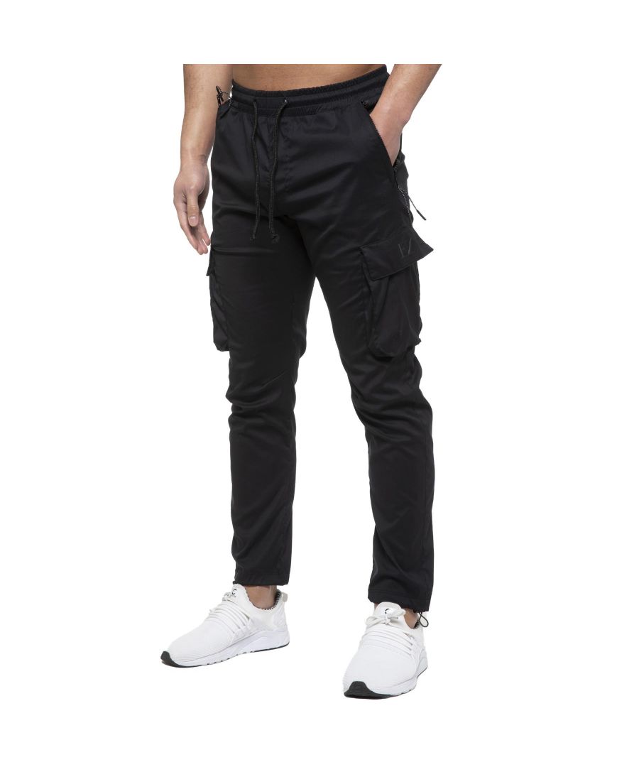 Enzo Mens Cargo Tech Fabric Trousers. Features 2 Front Zip Pockets, 2 Side Cargo Pockets With Velcro Fastening. Single Back Pocket With Zip Fastening. Elasticated Waist With Adjustable Drawstings. Adjustable Cuffed Ankle. Ideal For Casual or Workwear