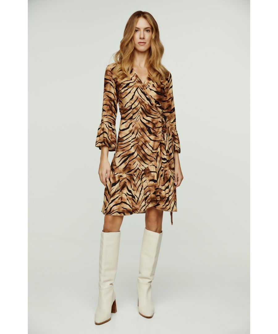 Deze wikkeljurk met tijgerprint is gemaakt van geweven viscose. Hij heeft een V-hals en 3/4 klokmouwen. Deze wikkeljurk heeft een das aan de linkerkant die door een gat aan de rechterkant gaat en die met de rechter das aan de zijkant of aan de achterkant wordt vastgemaakt. Over de hele zoom loopt een ruche van ongeveer 15 cm. De maten voor maat 36/S (in cm) zijn: Schouderbreedte-33, Buste-42, Taille-42, Zoomlijn-70, Mouwlengte -Lichaamslengte-95/100. 100% viscose
