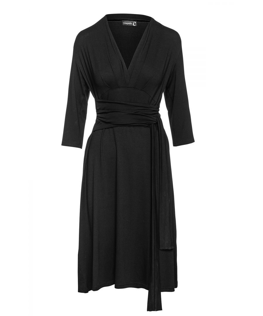 Black dress in stretch jersey fabric, viscose-elastane. ¾ sleeves with a deep V neckline with pleats on the left and right. Seam detail under the bust with pleats below. Belt in the same fabric fastened at the sides. Empire line with an A line silhouette. Knee length.
