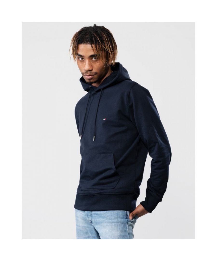 Inspired by the year that Tommy Hilfiger first designed his namesake label, our 1985 collection re-imagines archival icons with more sustainable materials.\nThis casual hoodie features understated branding on the chest and hood, and is made from stretchy terry fabric with a smooth feel.\nHighlights\n• Stretch organic cotton blend terry\n• Drawstring hooded neck\n• Kangaroo pocket\n• Tommy Hilfiger branding\n• Tommy Hilfiger flag embroidery on sleeve\nShape & fit\n• Regular fit\n• Our model is 5,11 and wears size M\nComposition & care\n• 65% organic cotton, 30% cotton, 5% elastane\nStyle\nMW0MW24352