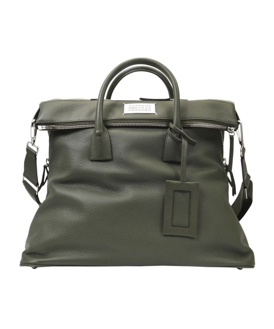 In gorgeous leather, soft to the touch, this bag from Maison Margiela is the epitome of the design house's style, where tradition meets the avant-garde. A functional yet seriously chic piece, it works well for everyday use, with a suit for a formal event or with a blazer and sneakers for a more casual thing. Top handle : 15 cm - Shoulder strap : 140 cm. Worn two ways - Two top handles and One adjustable. detachable shoulder strap. Material : Stag Leather. Lining : Cotton. Colour : Kaki - T7166 Militay. Closure : Top Zip. Interior : One zipped pocket.