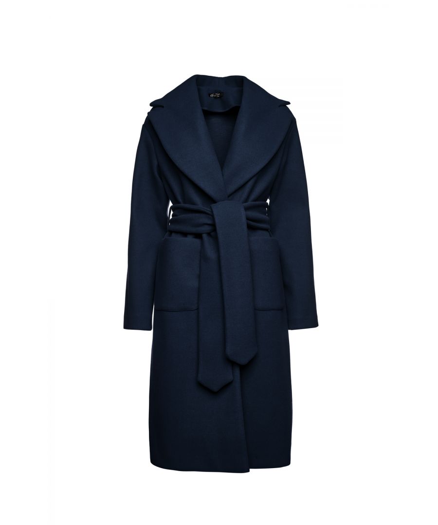 This long navy blue coat is crafted in faux mouflon style fabric. There are large square patch pockets on either side. It has a large lapel and drop shoulders. The coat fastens in the front with 2 large black plastic buttons. At the waist it has belt loops on the left and right so that it can be worn with the 9cm wide belt which is in the same fabric. The coat has big slits on either side. It is styled in a straight silhouette. This piece is ideal for wear in the day or for an evening out.