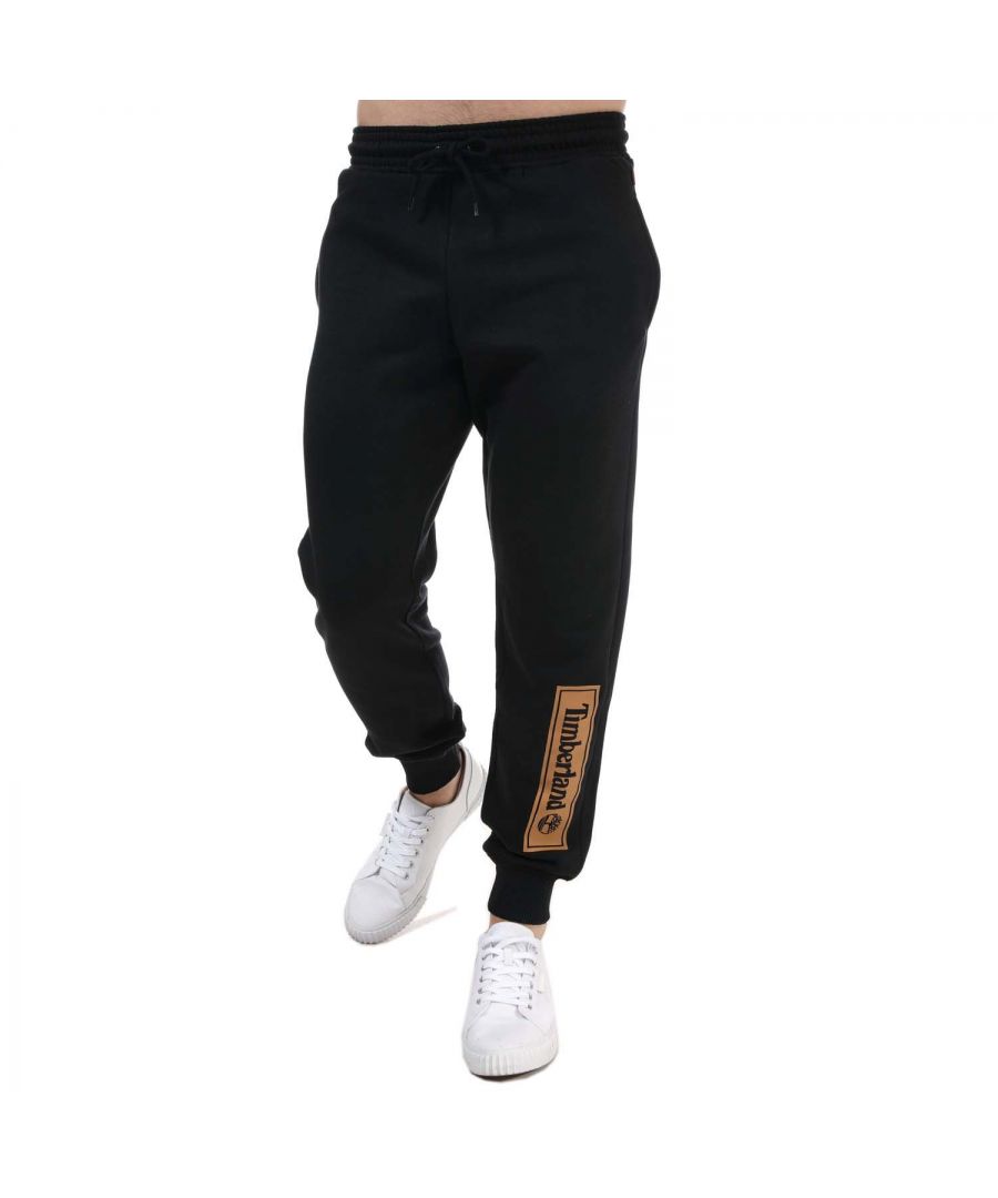 Mens Timberland Linear Logo Jog Pant in black.- Elasticated waistband with a woven drawstring fastening.- Two side pockets.- Ribbed cuffs at the ankles.- Logo print to leg.- Regular  tapered fit.- 90% Cotton  10% Polyester. - Ref: A5PMR0011