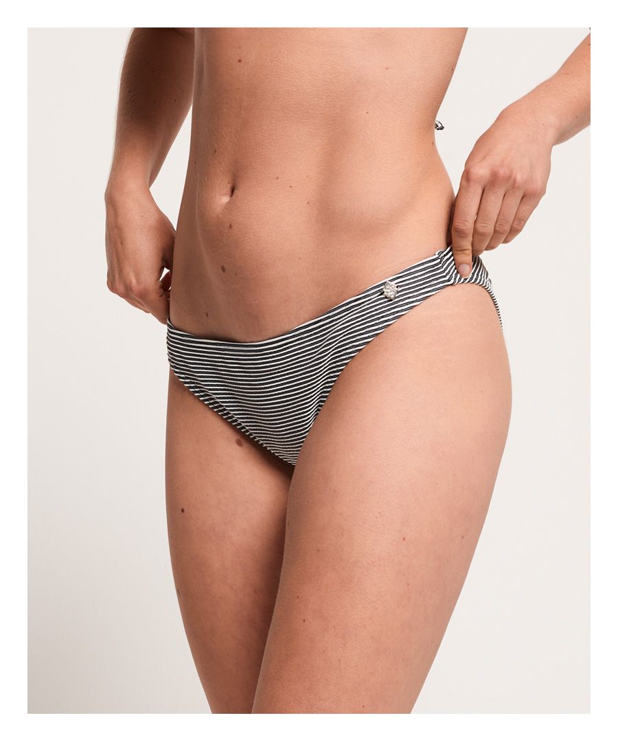 Superdry Marie Fixed Tri-bikinibroekje. Een klassiek bikinibroekje afgewerkt met een metalen Superdry-logo op de voorkant.Bijpassend broekje apart verkrijgbaar.Om hygiënische redenen kan badmode uitsluitend omgeruild of geretourneerd worden als de hygiënestrip nog intact is. Dit doet geen afbreuk aan je wettelijke rechten.