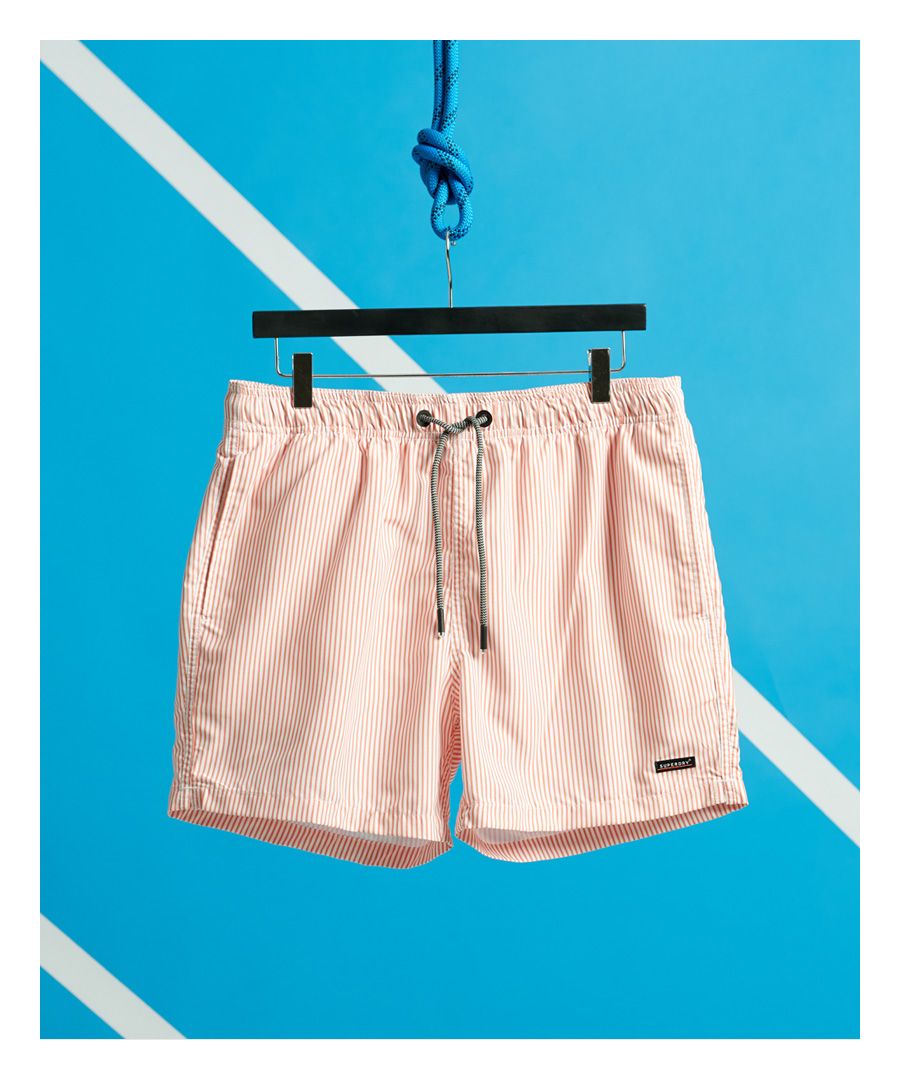 Superdry men's Edit swim shorts. The perfect solution to those over packed suitcases, these Edit swim shorts pack away for smart storage. Featuring an elasticated drawstring waist, two front pockets, mesh lining and a back zipped pocket. Finished with a Superdry logo patch towards the hemline.Please note due to hygiene reasons, we are unable to offer an exchange or refund on underwear, unless they are sealed in their original packaging. This does not affect your statutory rights.