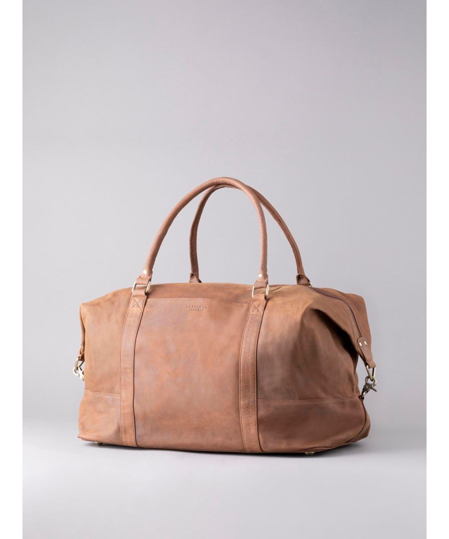 Our most popular leather holdall, the Hunter Leather Holdall in Tan is built to last and stand out from the crowd. Crafted from vintage style nubuck leather, this expandable structured holdall offers a classic worn-in look which may vary from bag to bag due to the uniqueness of the natural leather. Big enough to use as your main holiday travel bag, with heavy duty handles and adjustable strap. The zipped external pocket acts as a pass through pouch, allowing you to slip it over the telescopic handle of a suitcase.