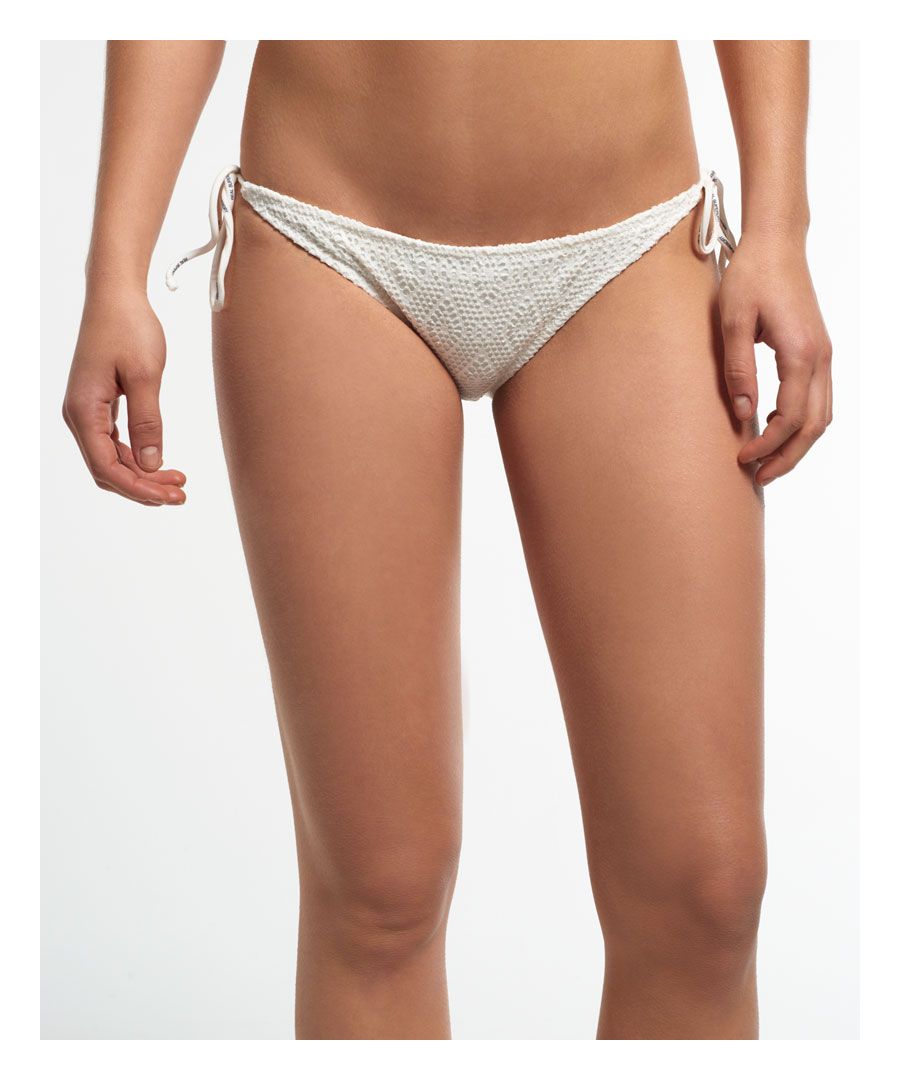 Superdry women's diamond lace bikini bottoms. A pair of lace bikini bottoms featuring spaghetti strap side ties and a subtle metal Superdry logo badge on the back of the waistband.Please note due to hygiene reasons, we are unable to offer an exchange or refund on underwear, unless they are sealed in their original packaging. This does not affect your statutory rights.