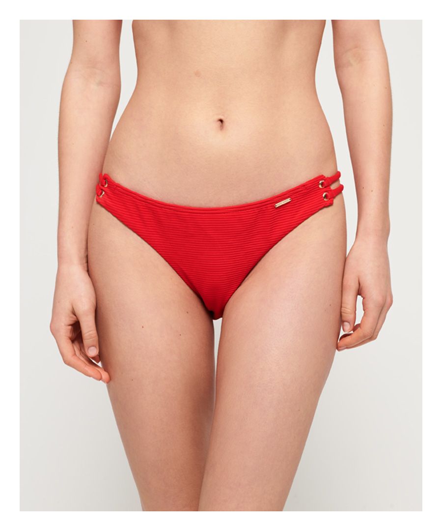 Superdry women's Alice textured cupped bikini bottoms. Make a splash this season in the Alice bikini bottoms. Classic in style, these bikini bottoms feature cut out side detailing and are completed with a metal logo badge on the waist.Matching top available.Please note due to hygiene reasons, we are unable to offer an exchange or refund on swimwear, unless they are sealed in their original packaging. This does not affect your statutory rights.