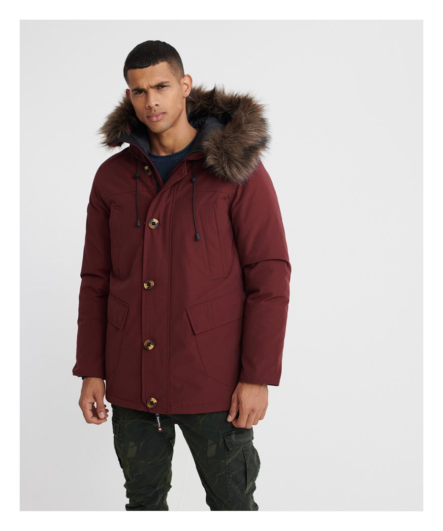 Superdry men’s Rookie Down Parka jacket. Keep the cold out this season in the Rookie Down Parka, filled with an 80/20 premium duck down filling and a medium fill power rating it's an essential item for your jacket collection. The jacket features a bungee cord adjustable hood, with detachable faux fur trim, zip and button fastening, four front pockets and one inside pocket. The Rookie Down Parka is completed with a Superdry logo badge on one sleeve and a rubber tab on the side seam. The Rookie Down Parka will make the perfect winter warmer this season.Superdry is certified by the Responsible Down Standard to confirm that our down filled products are sourced to ensure animal welfare.