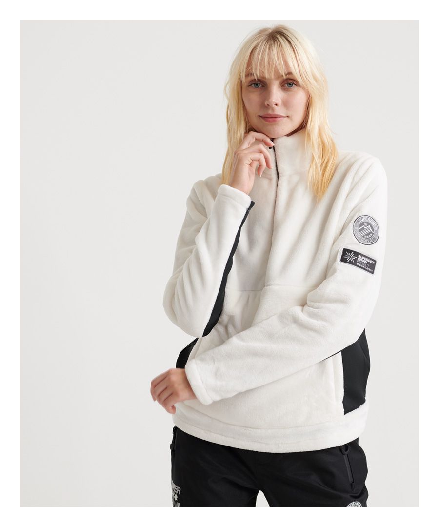 Superdry women's Storm Fleece midlayer half zip top. This ultra soft half zip top will make being cold the least of your worries on the slopes this season. Featuring a soft fleece material, a large front pocket with zip fastening and breathable panels under the arms. Finished with a Superdry Snow logo badges on one arm.