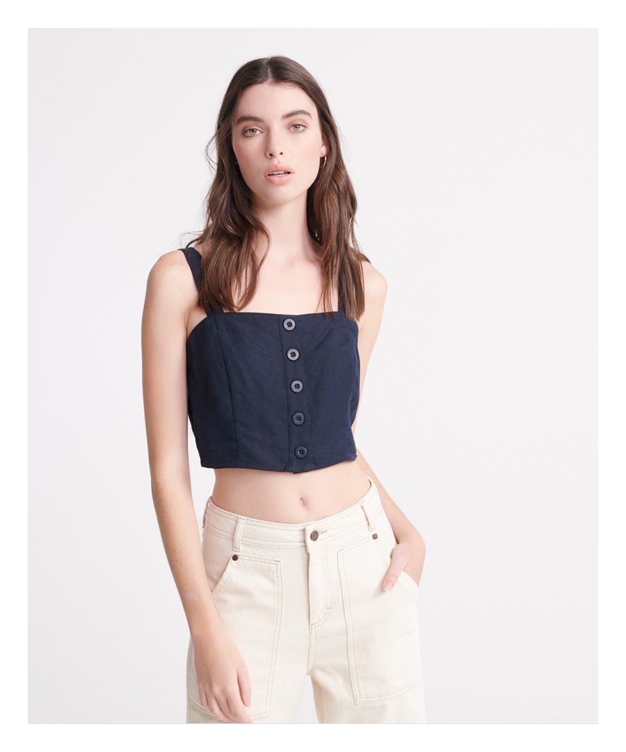 Superdry linnen Eden-damestop. Deze stijlvolle top is perfect te combineren met van alles, van relaxed denim tot een elegante rok. Deze top heeft een knoopsluiting en schouderbandjes met smokwerk aan de achterkant. Afgewerkt met een discreet metalen Superdry-logolabel boven de zoom.